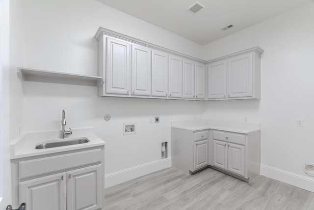 laundry room featuring sink, electric dryer hookup, hookup for a washing machine, cabinets, and hookup for a gas dryer