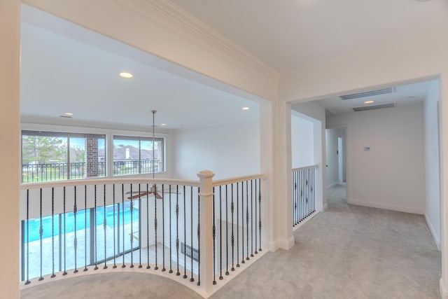 hallway featuring ornamental molding and light carpet