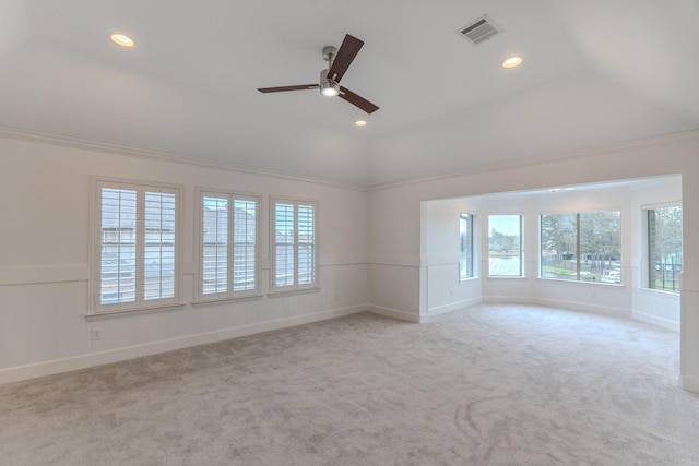 carpeted spare room featuring vaulted ceiling, ornamental molding, and ceiling fan