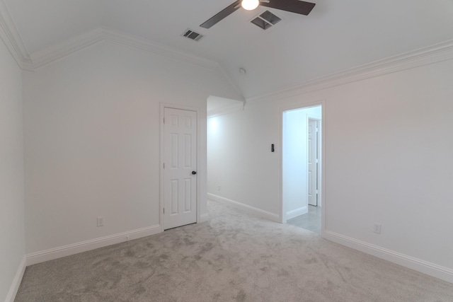 carpeted spare room featuring crown molding, ceiling fan, and vaulted ceiling