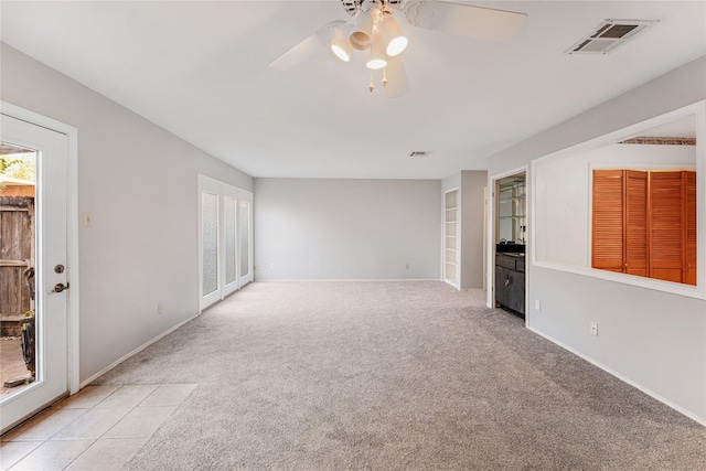 unfurnished living room featuring ceiling fan and light carpet