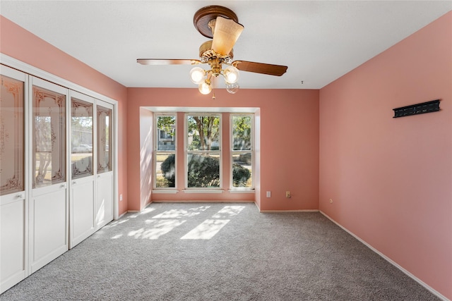 empty room with ceiling fan and light carpet