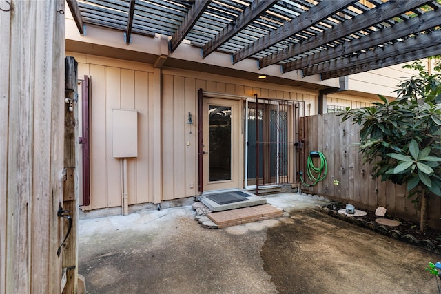 doorway to property with a patio area and a pergola