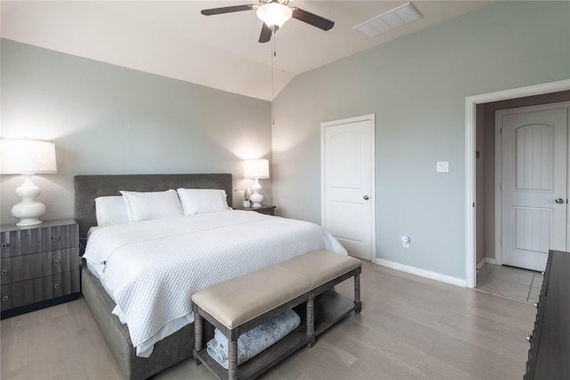 bedroom featuring ceiling fan, light hardwood / wood-style flooring, and lofted ceiling