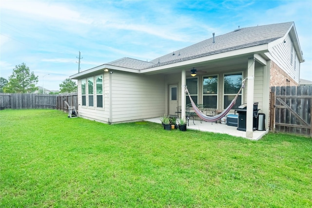 rear view of property featuring a lawn, ceiling fan, and a patio