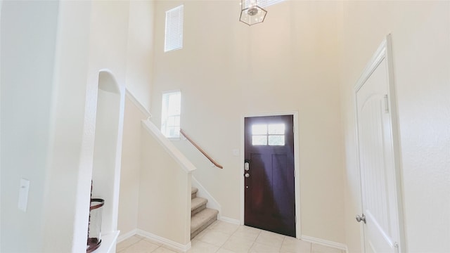 entryway featuring a towering ceiling and light tile patterned flooring