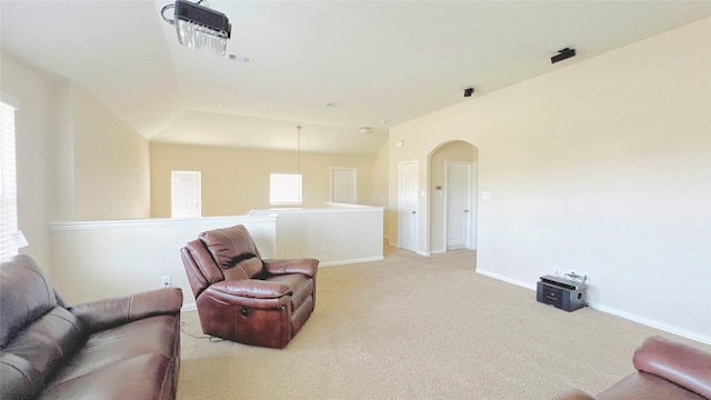 living area featuring lofted ceiling and light carpet