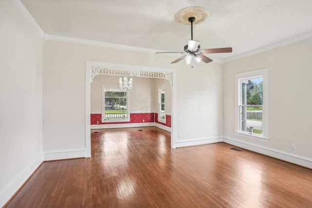 unfurnished room with ceiling fan with notable chandelier, hardwood / wood-style floors, and ornamental molding