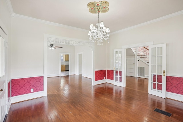 unfurnished room with wood-type flooring, a notable chandelier, crown molding, and french doors