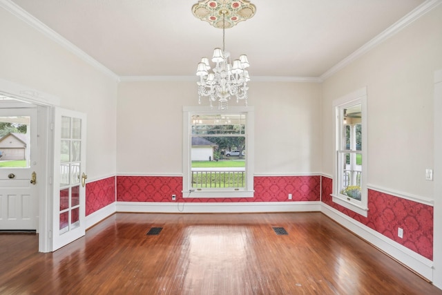 unfurnished dining area with hardwood / wood-style flooring, ornamental molding, and a notable chandelier