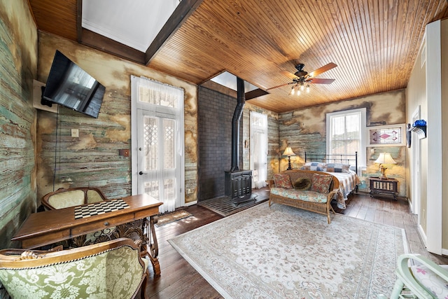 bedroom with dark hardwood / wood-style flooring, wood ceiling, french doors, and a wood stove