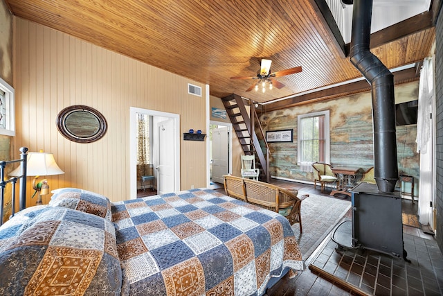 bedroom with a wood stove and wood ceiling