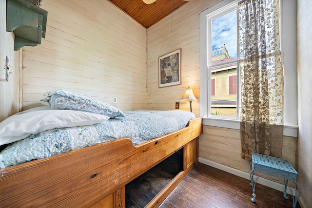 bedroom featuring dark wood-type flooring, wooden ceiling, and wood walls