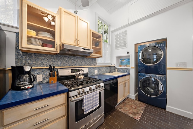 kitchen with sink, gas range, light brown cabinets, black dishwasher, and stacked washer / dryer