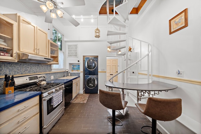 kitchen with backsplash, stainless steel range with gas stovetop, black dishwasher, stacked washer / dryer, and light brown cabinets