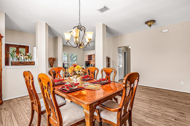 dining area featuring light wood-type flooring and a notable chandelier