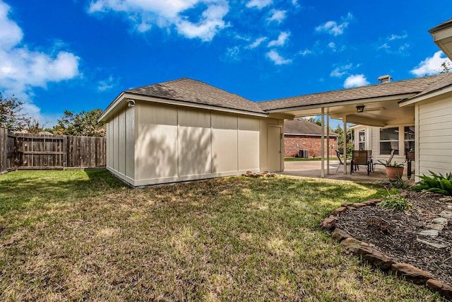 rear view of property featuring a storage unit, a patio, and a yard