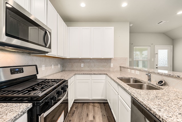 kitchen with sink, light stone counters, white cabinets, and appliances with stainless steel finishes