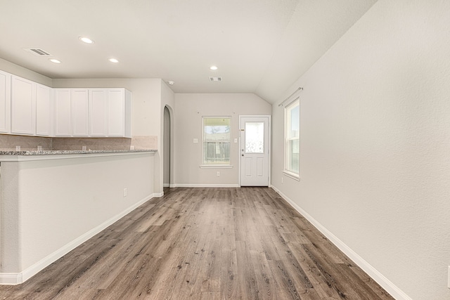 foyer entrance with vaulted ceiling and wood-type flooring