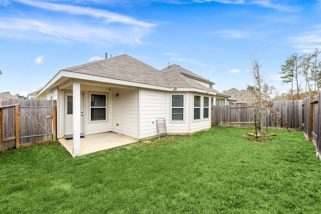 rear view of house featuring a yard and a patio