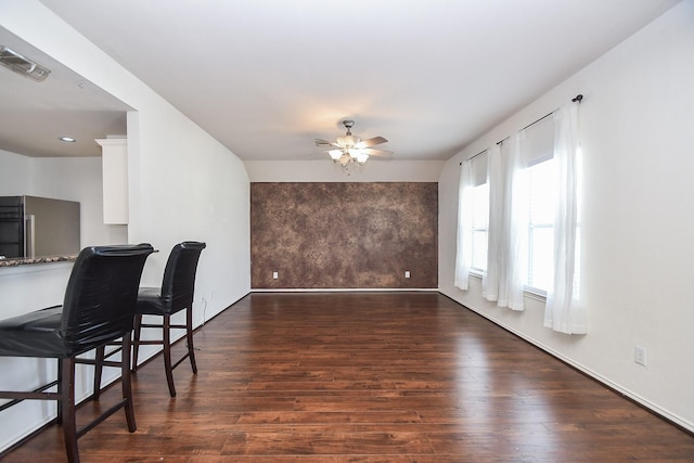 dining area with ceiling fan and dark wood-type flooring