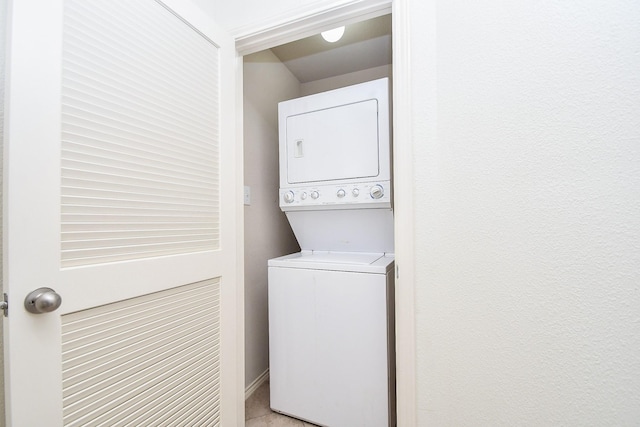 washroom with light tile patterned floors and stacked washer / drying machine