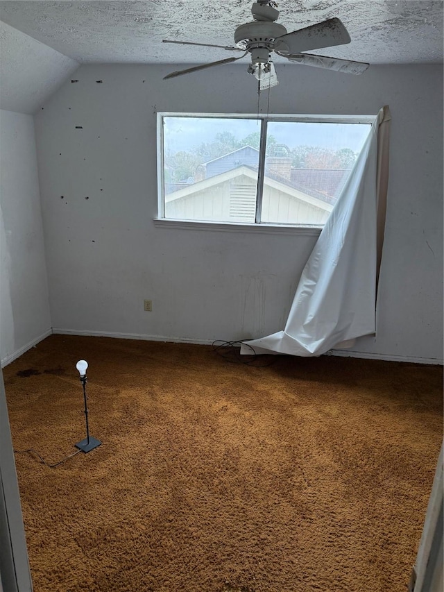 bonus room featuring ceiling fan, carpet, a textured ceiling, and lofted ceiling