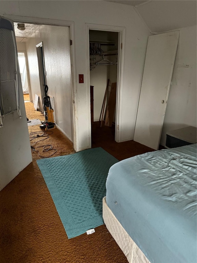 bedroom featuring dark colored carpet and lofted ceiling