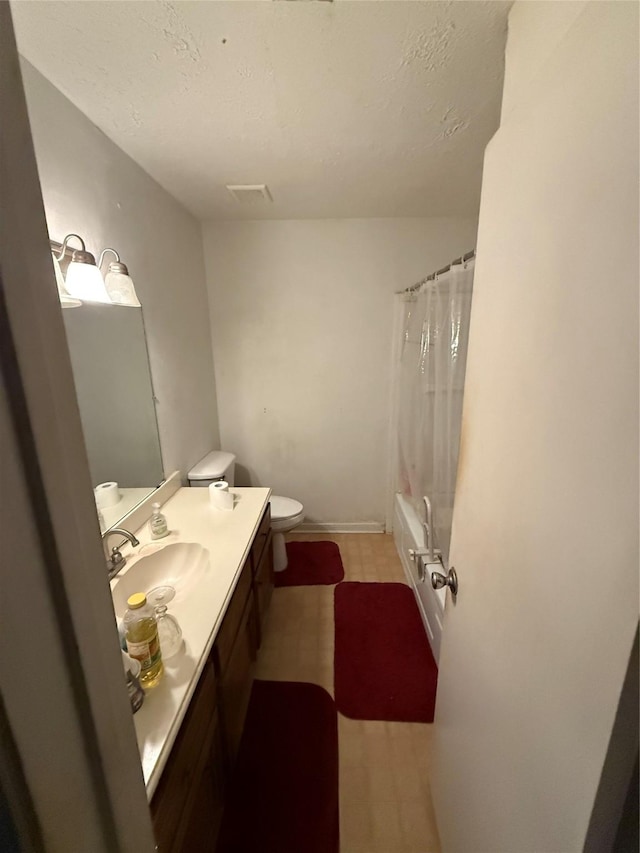 full bathroom with a textured ceiling, shower / bath combo with shower curtain, toilet, and vanity