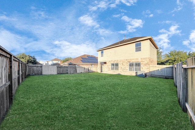 rear view of property with a lawn and central air condition unit