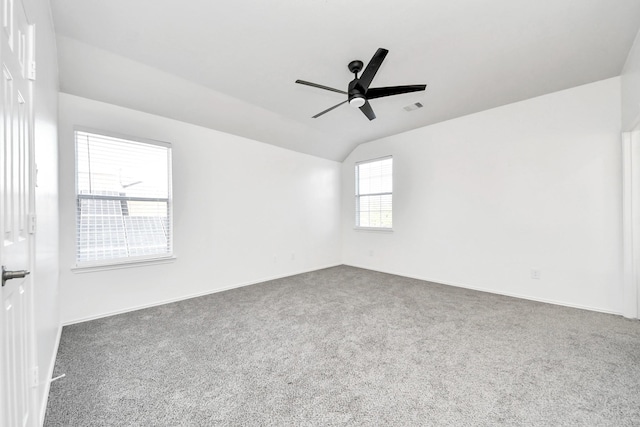 empty room featuring ceiling fan, lofted ceiling, and dark carpet