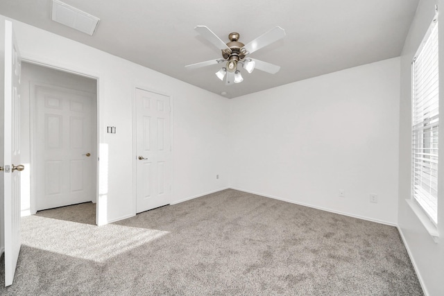 spare room featuring ceiling fan, a healthy amount of sunlight, and light carpet