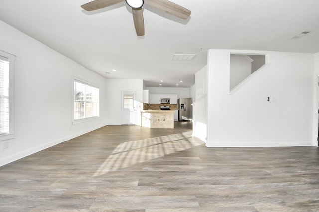 unfurnished living room with hardwood / wood-style flooring and ceiling fan