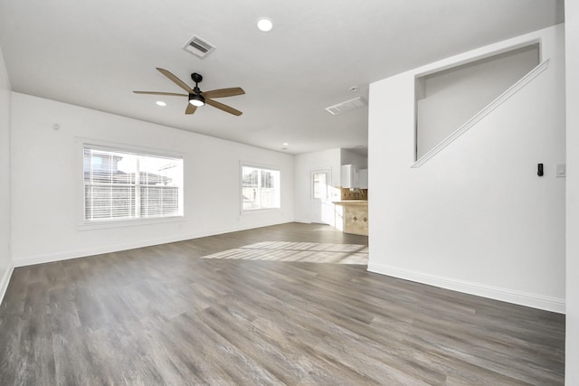 unfurnished living room featuring dark hardwood / wood-style flooring and ceiling fan