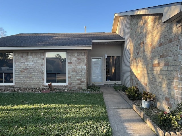 view of exterior entry with a yard