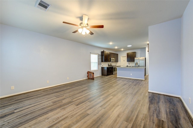 unfurnished living room featuring ceiling fan and dark hardwood / wood-style flooring