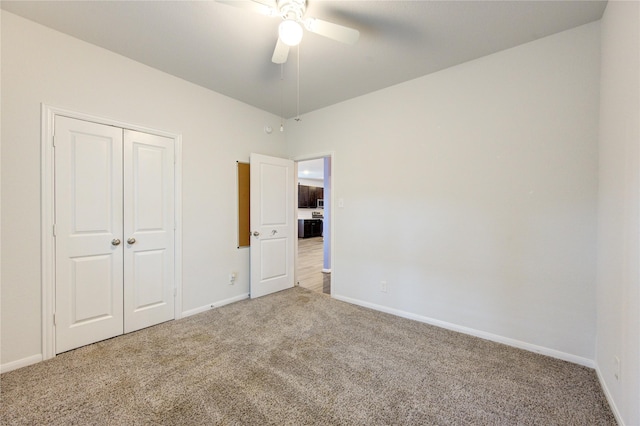 unfurnished bedroom with ceiling fan, a closet, and carpet