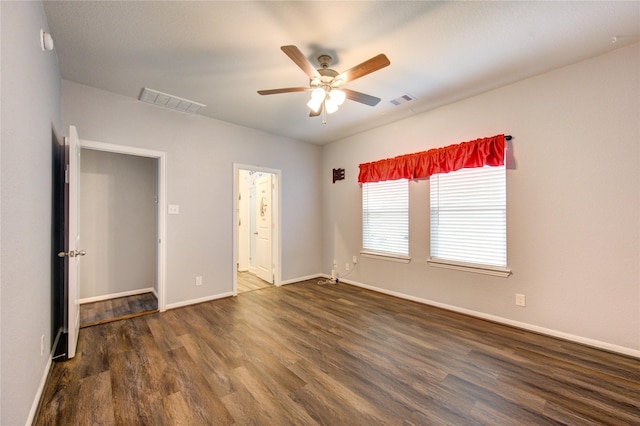 unfurnished bedroom with ceiling fan, ensuite bathroom, and dark hardwood / wood-style flooring