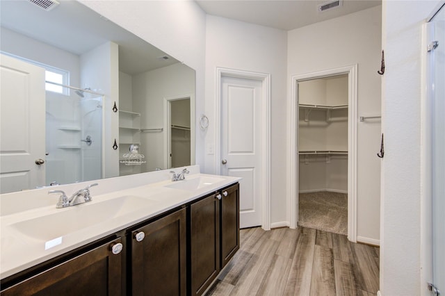 bathroom featuring vanity, hardwood / wood-style floors, and walk in shower