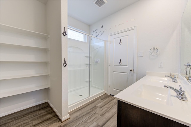 bathroom with wood-type flooring, an enclosed shower, and vanity