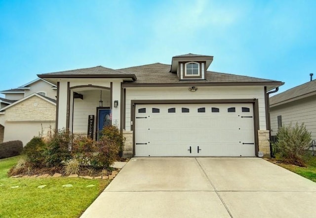 view of front of property with a garage and a front yard