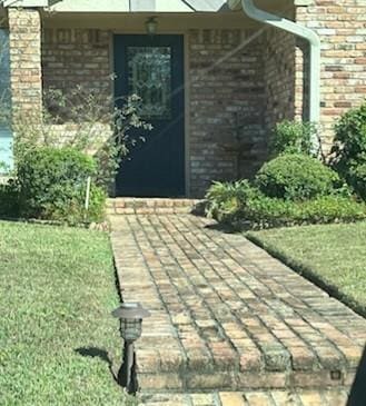 view of exterior entry featuring a yard