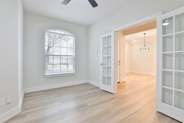 empty room with light hardwood / wood-style floors, french doors, and ceiling fan