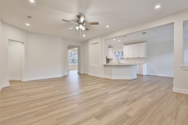 unfurnished living room featuring ceiling fan and light hardwood / wood-style flooring