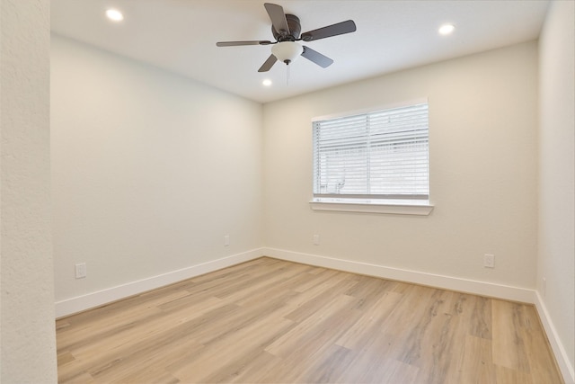 empty room with ceiling fan and light hardwood / wood-style flooring