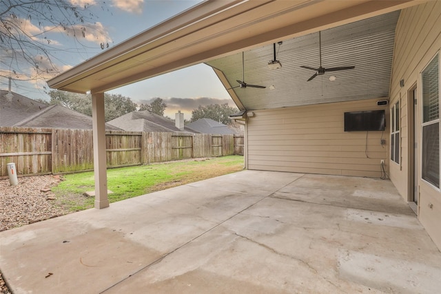 patio terrace at dusk with a lawn and ceiling fan