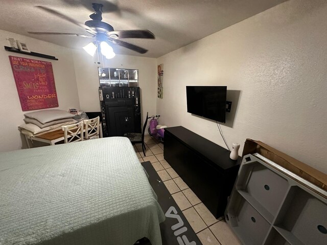 bedroom featuring a textured ceiling, light tile patterned floors, and ceiling fan