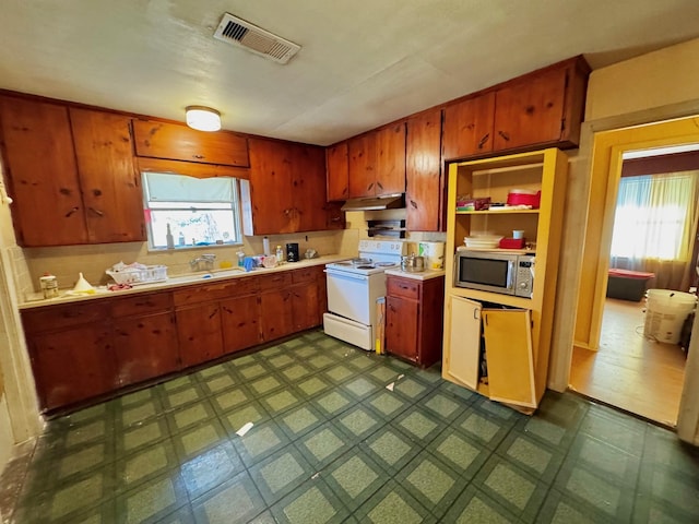 kitchen featuring sink, electric range, and a healthy amount of sunlight