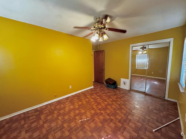 unfurnished bedroom with a closet, ceiling fan, and parquet flooring