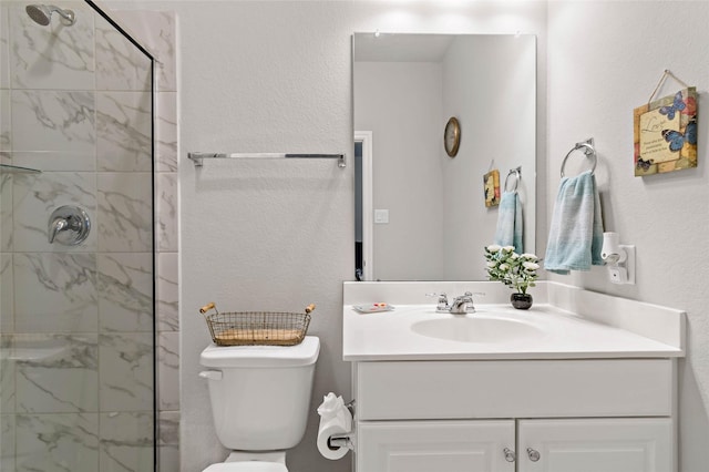 bathroom featuring a tile shower, toilet, and vanity